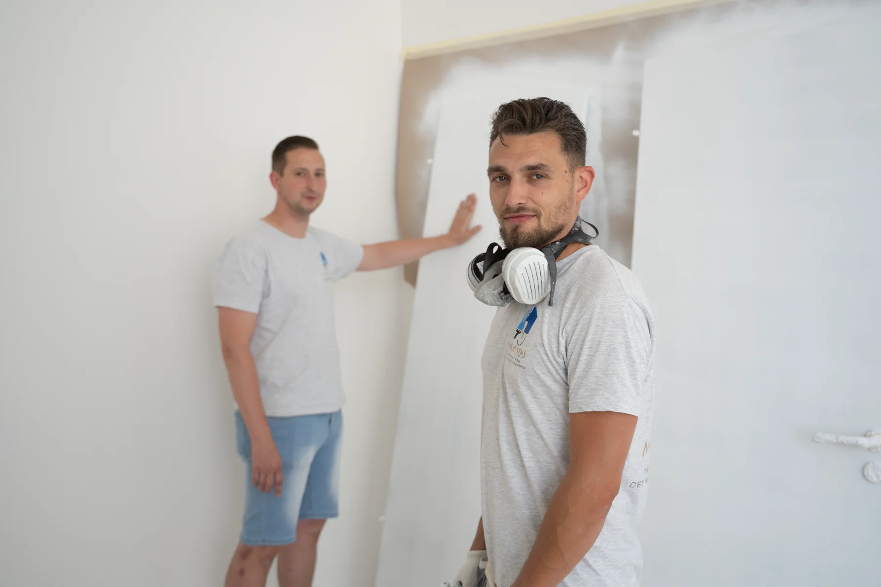 Zwei Kollegen beim Tapezieren